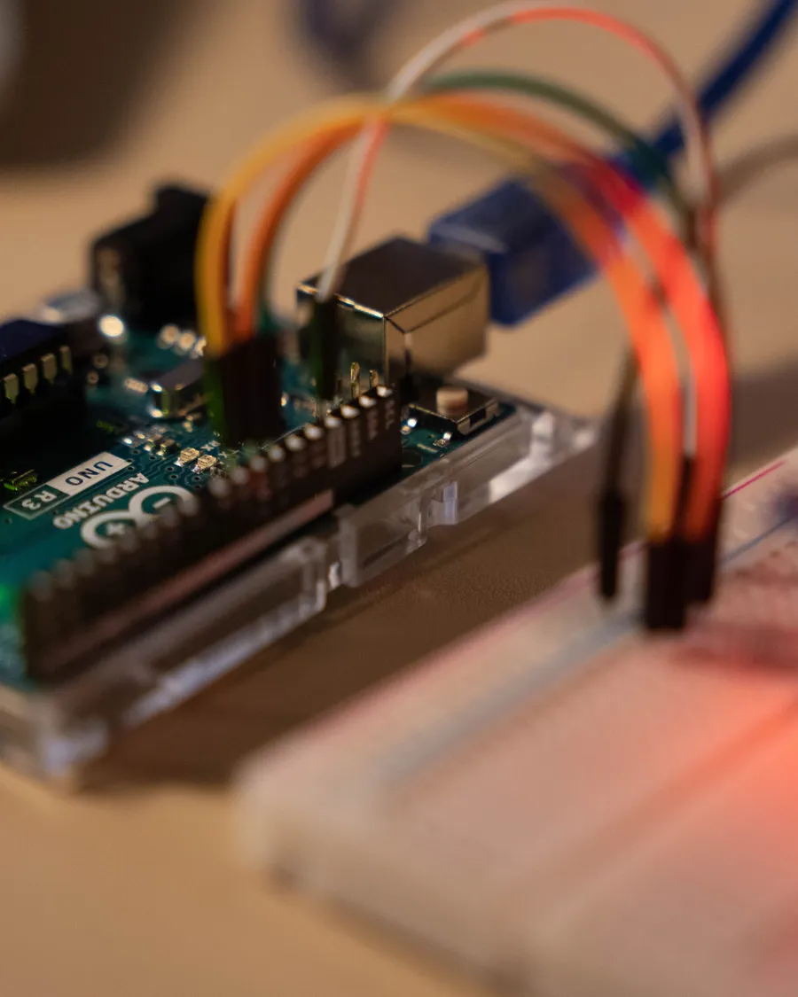 A microcontroller board wired to a breadboard on a lab bench, representing companion-computer and embedded systems work